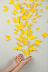 Paper yellow butterflies fly on wall in different directions