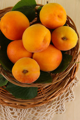 Apricots on wicker coasters on napkin on  wooden table