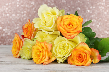 Beautiful bouquet of roses on table on brown background