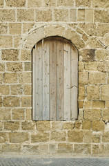 Fototapeta na wymiar Zabite deskami okna zabytkowej kamienicy