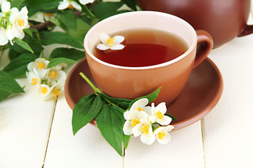Cup of tea with jasmine, on wooden table, close-up