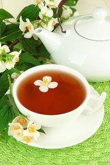 Cup of tea with jasmine, on wicker mat background