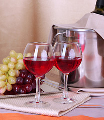 Vine and glasses on round table on cloth background