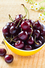 Heap of sweet cherries in the yellow bowl