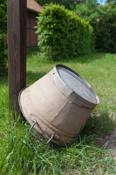 Eine alte Blechwanne vor einem Bauernhaus