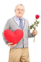 Mature gentleman holding a red heart and flower