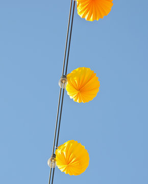 farolillos amarillos de feria sobre cielo azul