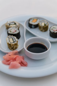 Ein Teller mit Sushi und Ingewer auf weisser Tischdecke