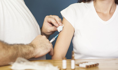 Doctor preparing to vaccinate a woman against flu