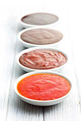 various barbecue sauces in ceramic bowls