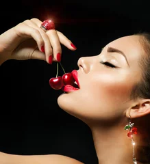 Sexy Frau, die Kirsche isst. Sinnliche rote Lippen mit Kirschen © Subbotina Anna