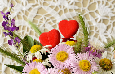Obraz premium Bouquet of chamomiles and two hearts