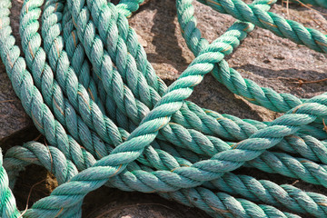 Green naval rope lies on the stone coast