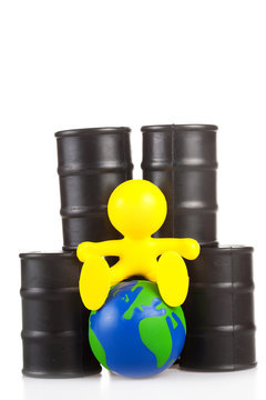 toy  little man sits next on butts to oil the globe.