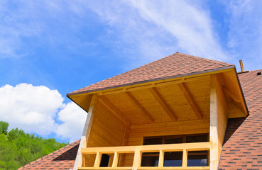 Dormer with a balcony on top of a house