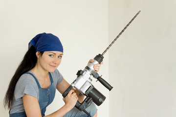 Young DIY woman holding an electric drill
