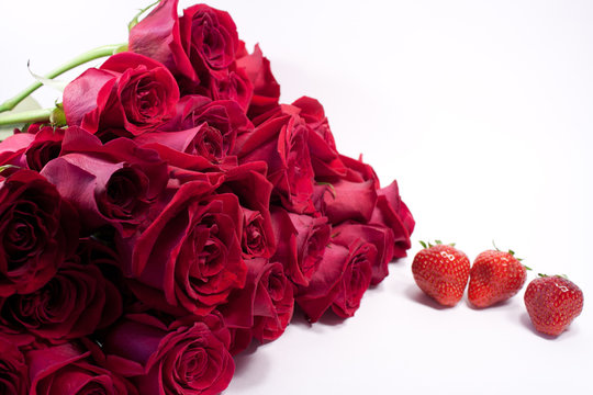 A bouquet of red roses and strawberries