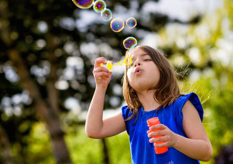 beautiful child blowing bubbles