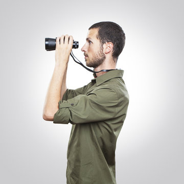 young man looking through binoculars, surprise face expression