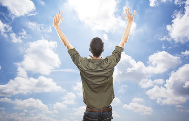 young man enjoying freedom on blue sky background