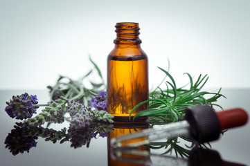 Essential oil bottle with lavender flowers and rosemary - 53083820
