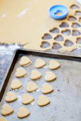 Heart shaped raw cookies on metal baking tray, selective focus