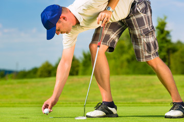 Obraz premium Young golf player on course putting