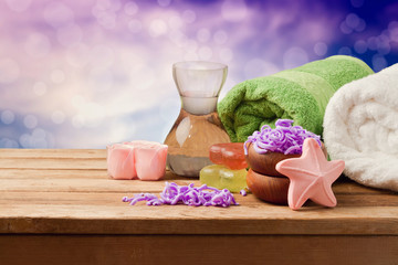 Spa setting with soap and towels on wooden table