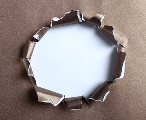 Hole ripped in brown paper