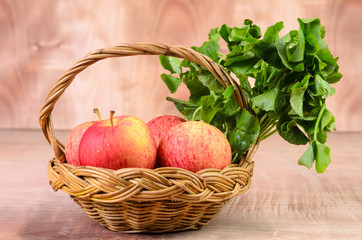 Apple and Asiatic in basket on wood background