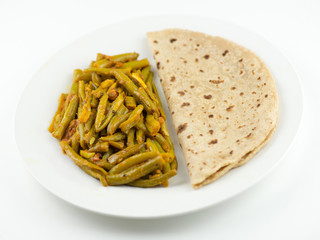 Indian roti and green bean sabzi on white background
