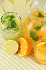 Orange and lemon lemonade in pitchers and glasses