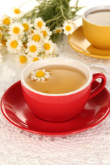Cups of herbal tea with camomiles close up