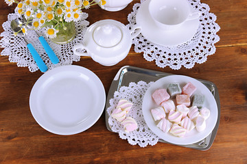 Table setting with chamomiles on wooden table