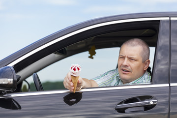 Man sitting in a car offers ice cream
