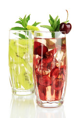 Glasses of fruit drinks with ice cubes isolated on white