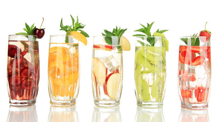 Glasses of fruit drinks with ice cubes isolated on white