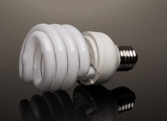 Eco light bulb at black background with reflection