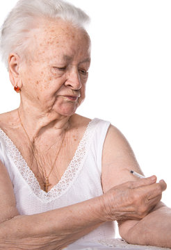 Old woman  giving herself an injection of insulin
