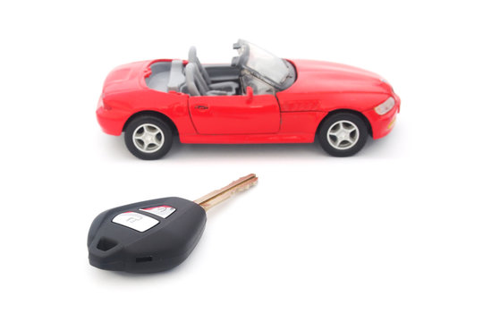 key and toy red car on white background