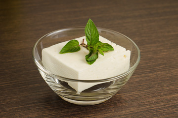 A piece of White Cheese in Glass Bowl