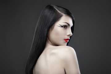 Brunette woman with long straight hair on dark