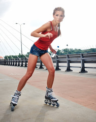 Young woman on roller skates - obrazy, fototapety, plakaty