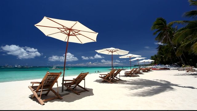 Sun umbrellas and beach chairs on coasline 