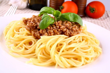 Delicious spaghetti bolognese with basil leaves