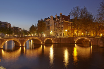 Fototapeta premium Amsterdam, Niederlande - Gracht in der Abenddämmerung