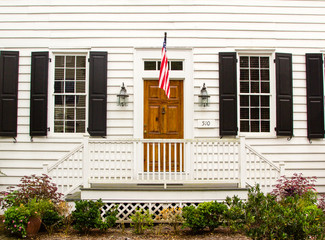 brown wooden door in a white wooden wall with US flag