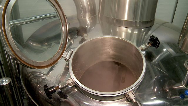Stirring of a wort mash in large steel vats at the brewhouse