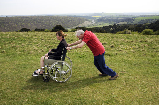 Carer Pushing Woman In A Wheelchair