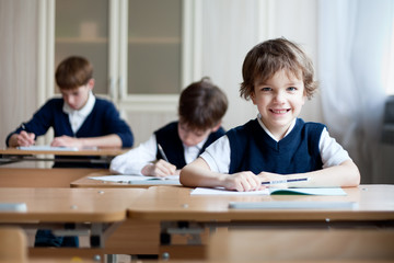 Fototapeta na wymiar Diligent student sitting at desk, classroom